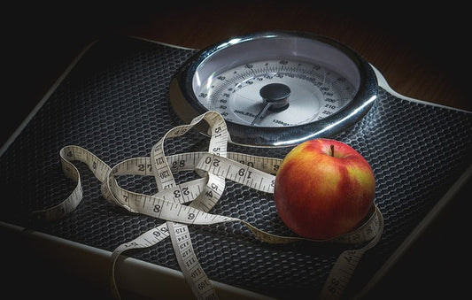 A measuring tape, an apple and a scale